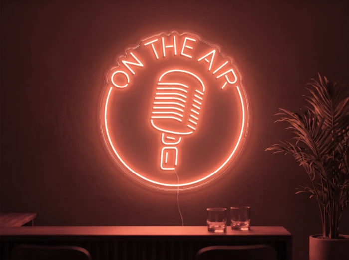 Neonskylt «On The Air» i röd LED-neon, monterad på vägg