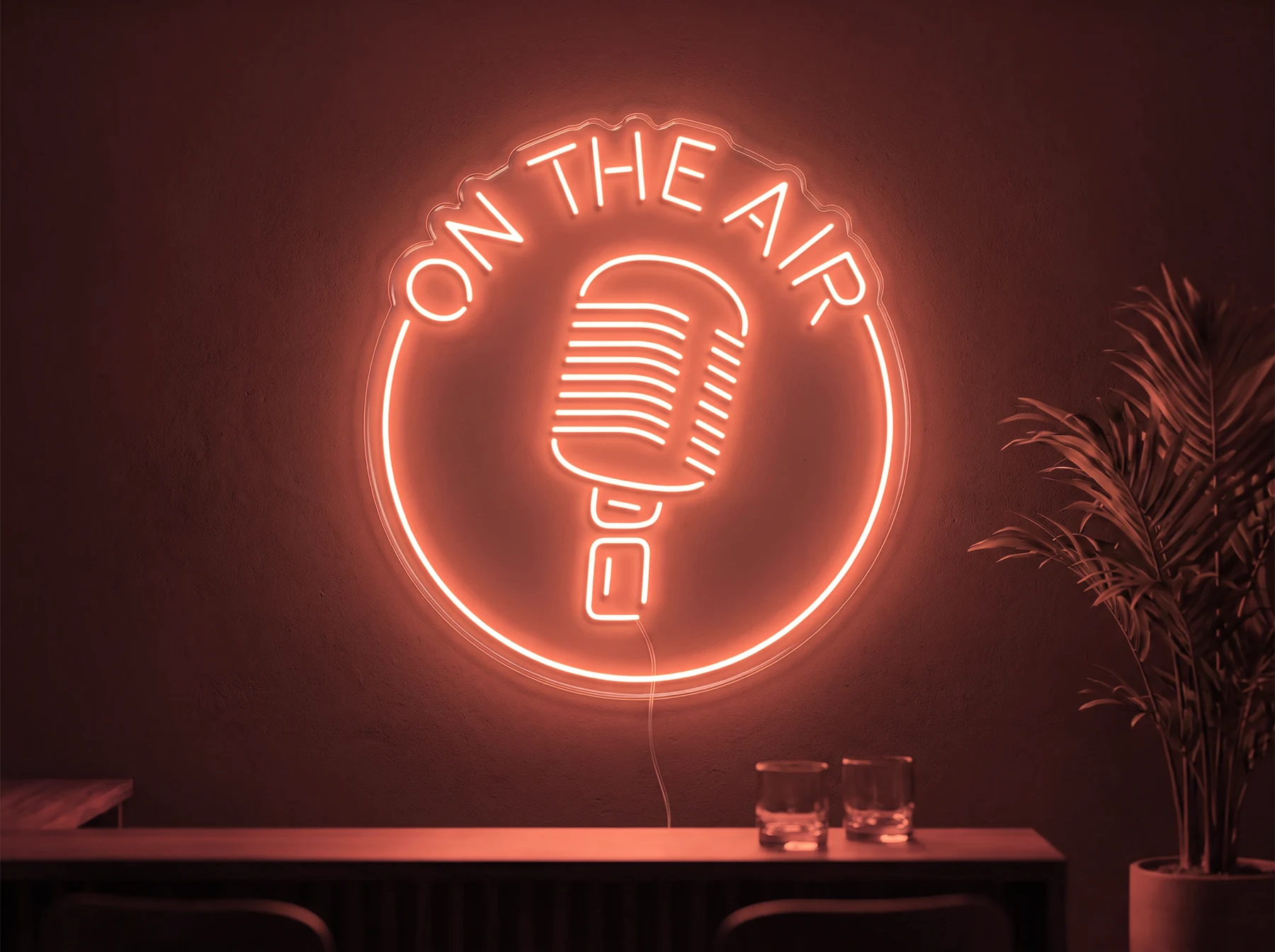Neonskylt «On The Air» i röd LED-neon, monterad på vägg