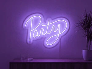Neonskylt «Party» i lila LED-neon, monterad på vägg