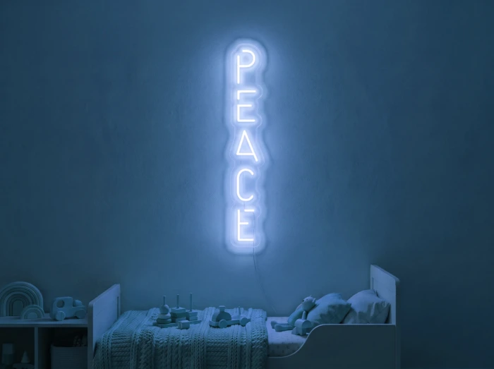 Neonskylt «Peace» i isblå LED-neon, monterad på vägg
