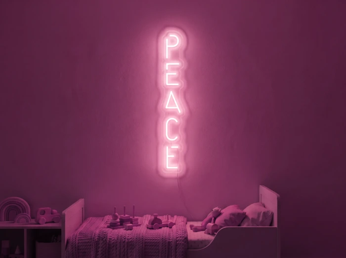 Neonskylt «Peace» i rosa LED-neon, monterad på vägg
