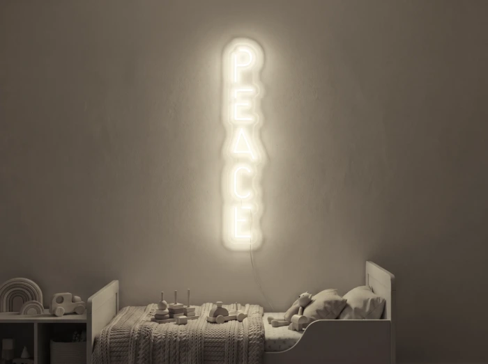 Neonskylt «Peace» i varmvit LED-neon, monterad på vägg