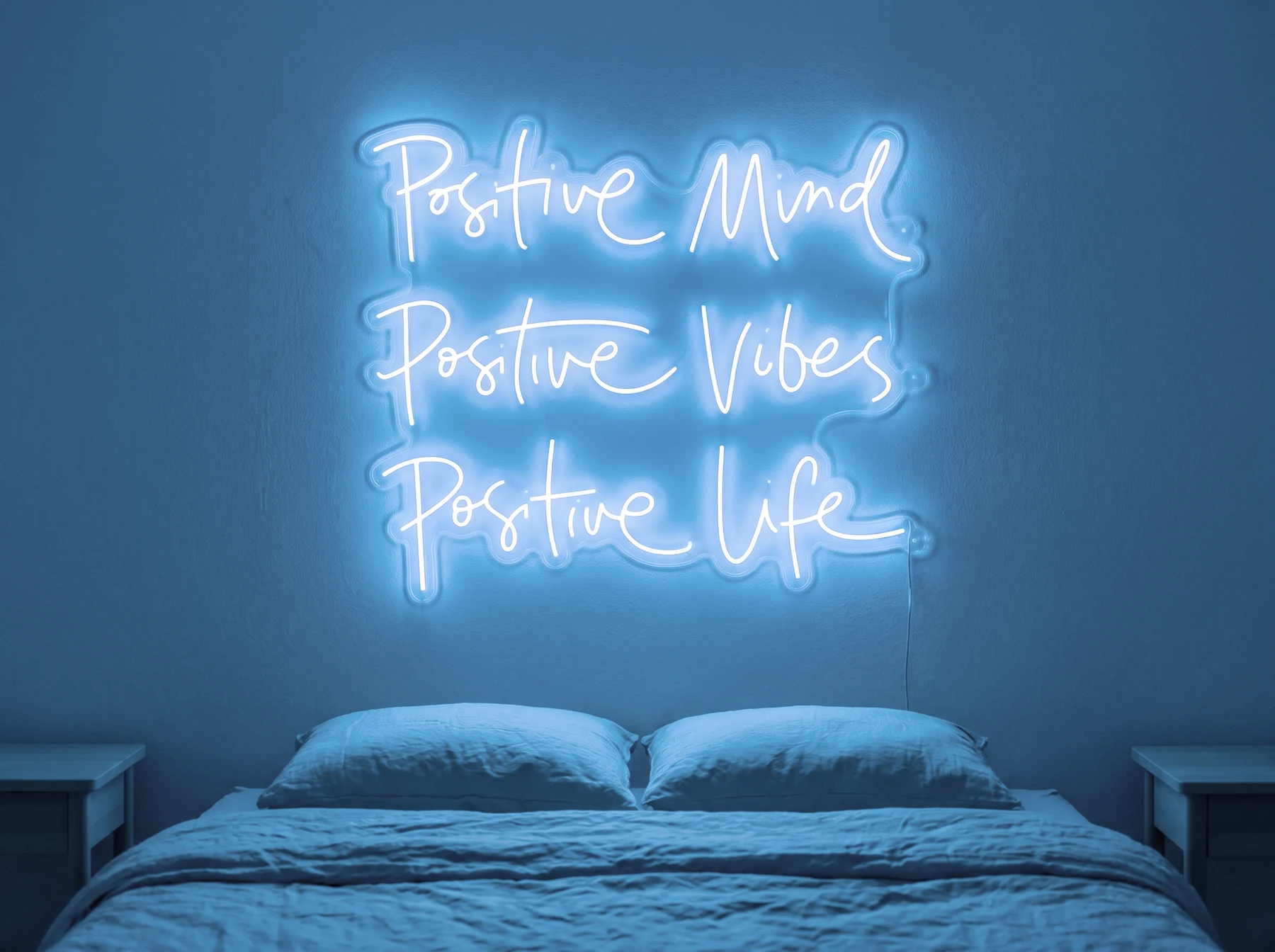 Neonskylt «Positive Mind, Vibes, Life» i isblå LED-neon, monterad på vägg