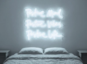 Neonskylt «Positive Mind, Vibes, Life» i iskall vit LED-neon, monterad på vägg