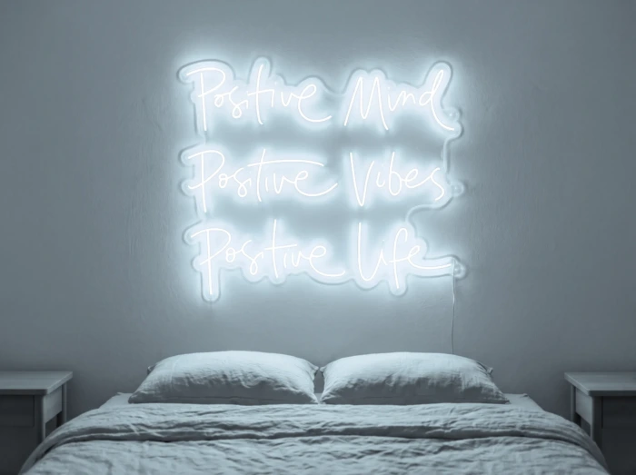 Neonskylt «Positive Mind, Vibes, Life» i iskall vit LED-neon, monterad på vägg