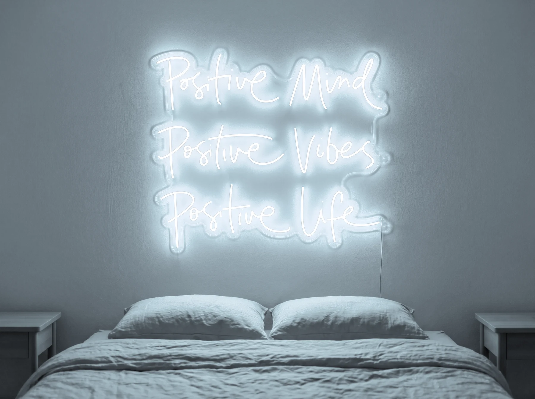 Neonskylt «Positive Mind, Vibes, Life» i iskall vit LED-neon, monterad på vägg