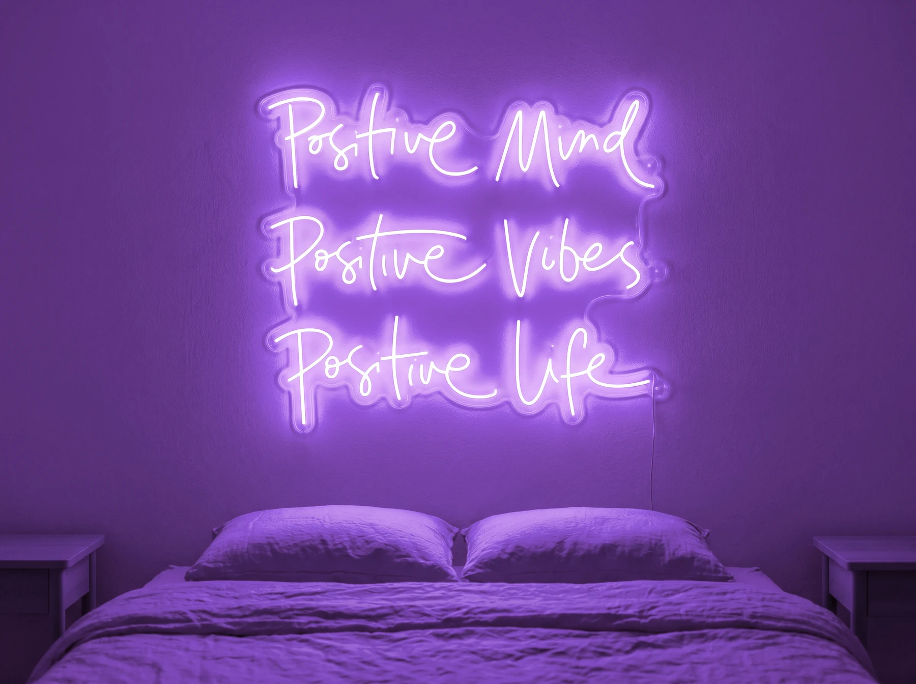 Neonskylt «Positive Mind, Vibes, Life» i lila LED-neon, monterad på vägg