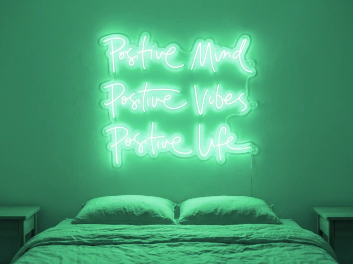 Neonskylt «Positive Mind, Vibes, Life» i mintgrön LED-neon, monterad på vägg