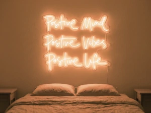 Neonskylt «Positive Mind, Vibes, Life» i orange LED-neon, monterad på vägg