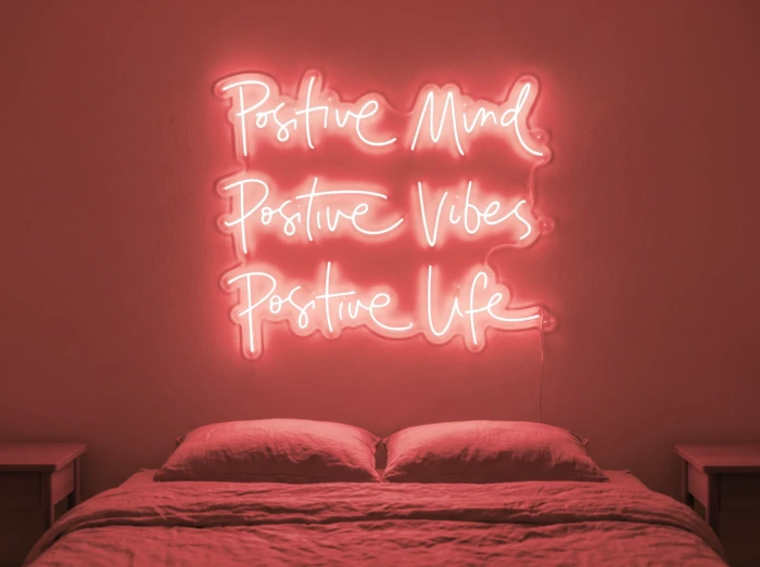 Neonskylt «Positive Mind, Vibes, Life» i röd LED-neon, monterad på vägg