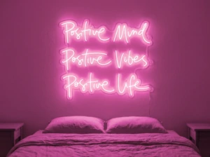 Neonskylt «Positive Mind, Vibes, Life» i rosa LED-neon, monterad på vägg