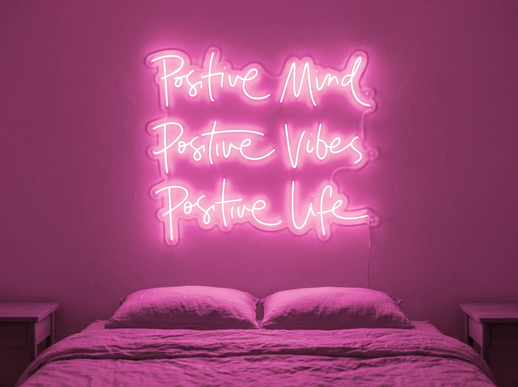 Neonskylt «Positive Mind, Vibes, Life» i rosa LED-neon, monterad på vägg