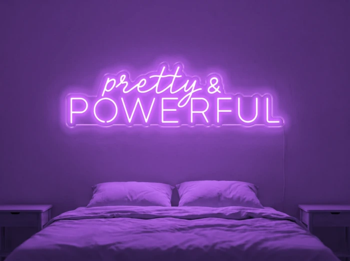 Neonskylt «Pretty And Powerful» i lila LED-neon, monterad på vägg