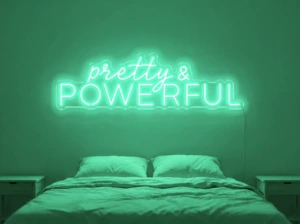 Neonskylt «Pretty And Powerful» i mintgrön LED-neon, monterad på vägg