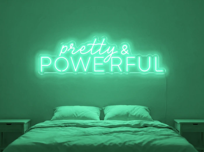 Neonskylt «Pretty And Powerful» i mintgrön LED-neon, monterad på vägg
