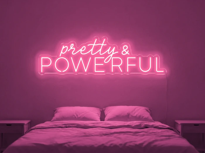 Neonskylt «Pretty And Powerful» i rosa LED-neon, monterad på vägg