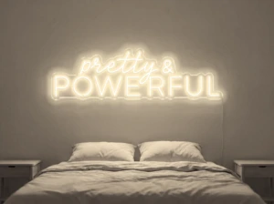 Neonskylt «Pretty And Powerful» i varmvit LED-neon, monterad på vägg