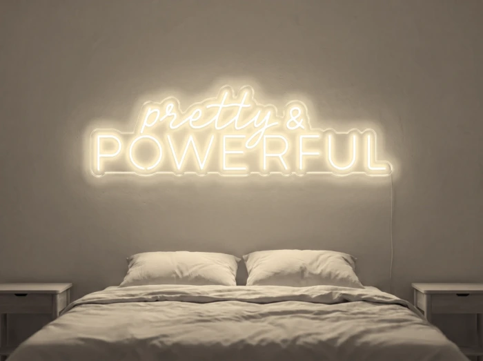 Neonskylt «Pretty And Powerful» i varmvit LED-neon, monterad på vägg