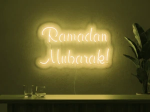 Neonskylt «Ramadan Mubarak» i gul LED-neon, monterad på vägg