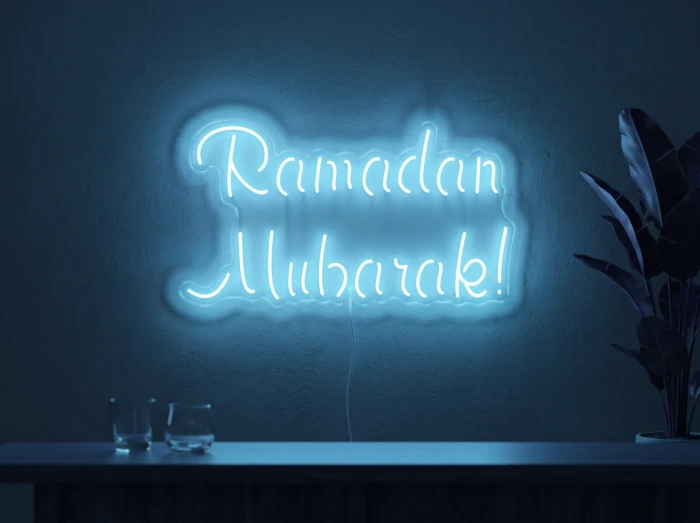 Neonskylt «Ramadan Mubarak» i isblå LED-neon, monterad på vägg