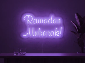 Neonskylt «Ramadan Mubarak» i lila LED-neon, monterad på vägg