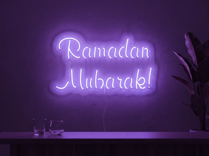 Neonskylt «Ramadan Mubarak» i lila LED-neon, monterad på vägg