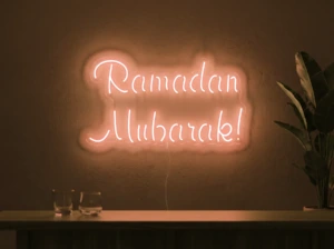 Neonskylt «Ramadan Mubarak» i orange LED-neon, monterad på vägg