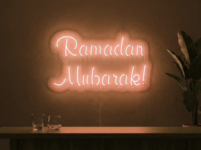 Neonskylt «Ramadan Mubarak» i orange LED-neon, monterad på vägg