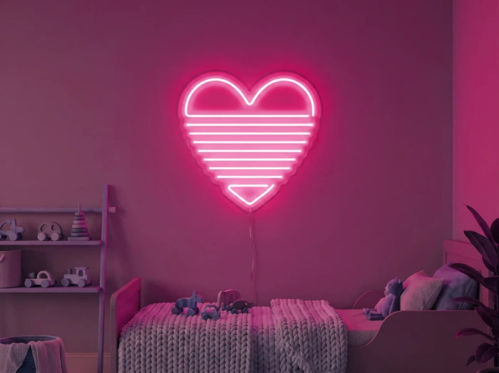 Neonskylt «Regnbågshjärta» i rosa LED-neon, monterad på vägg