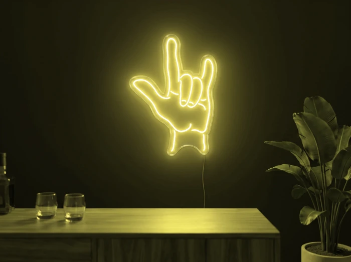 Neonskylt «Rock-hand» i gul LED-neon, monterad på vägg