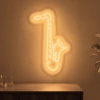 Neonskylt «Saxofon» i orange LED-neon, monterad på vägg