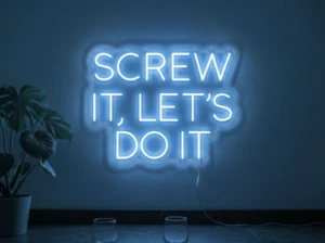 Neonskylt «Screw It Let’s Do It» i isblå LED-neon, monterad på vägg