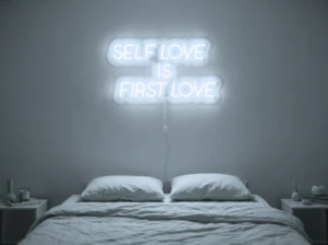 Neonskylt «Self Love Is First Love» i iskall vit LED-neon, monterad på vägg
