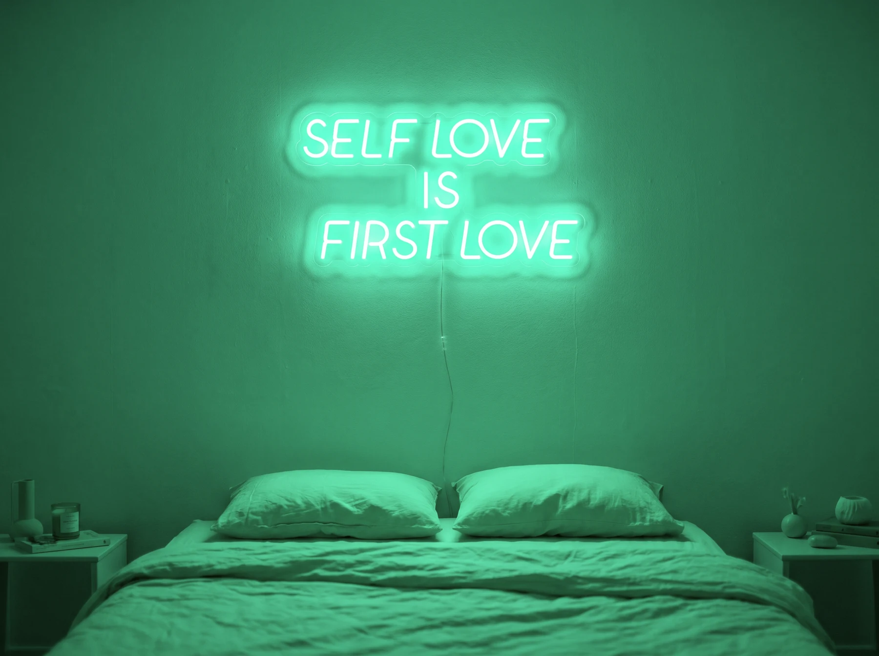 Neonskylt «Self Love Is First Love» i mintgrön LED-neon, monterad på vägg