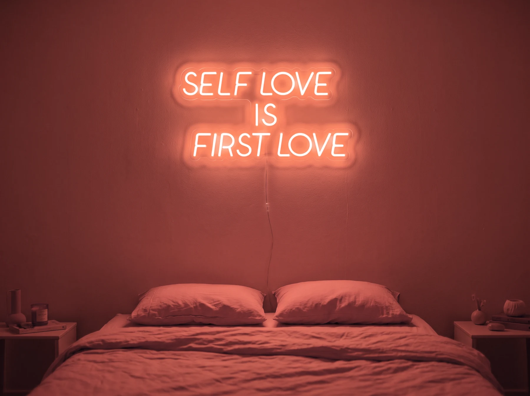 Neonskylt «Self Love Is First Love» i röd LED-neon, monterad på vägg