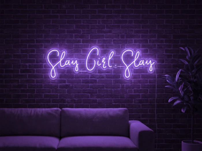 Neonskylt «Slay Girl Slay» i lila LED-neon, monterad på vägg