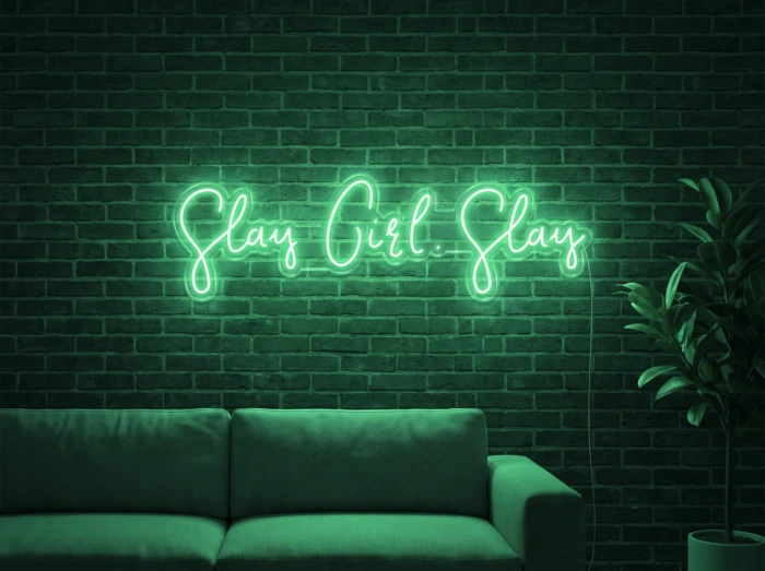 Neonskylt «Slay Girl Slay» i mintgrön LED-neon, monterad på vägg