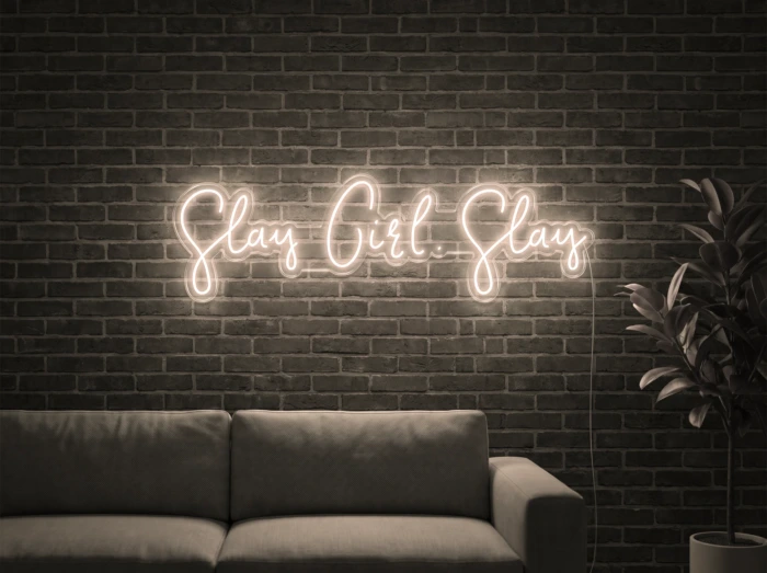 Neonskylt «Slay Girl Slay» i varmvit LED-neon, monterad på vägg