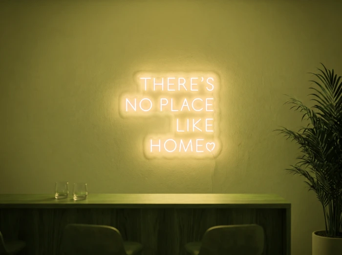 Neonskylt «There’s No Place Like Home, versaler» i gul LED-neon, monterad på vägg