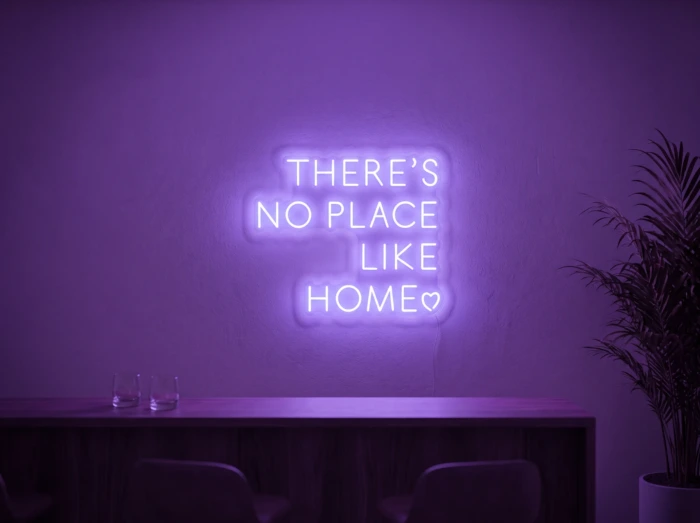 Neonskylt «There’s No Place Like Home, versaler» i lila LED-neon, monterad på vägg