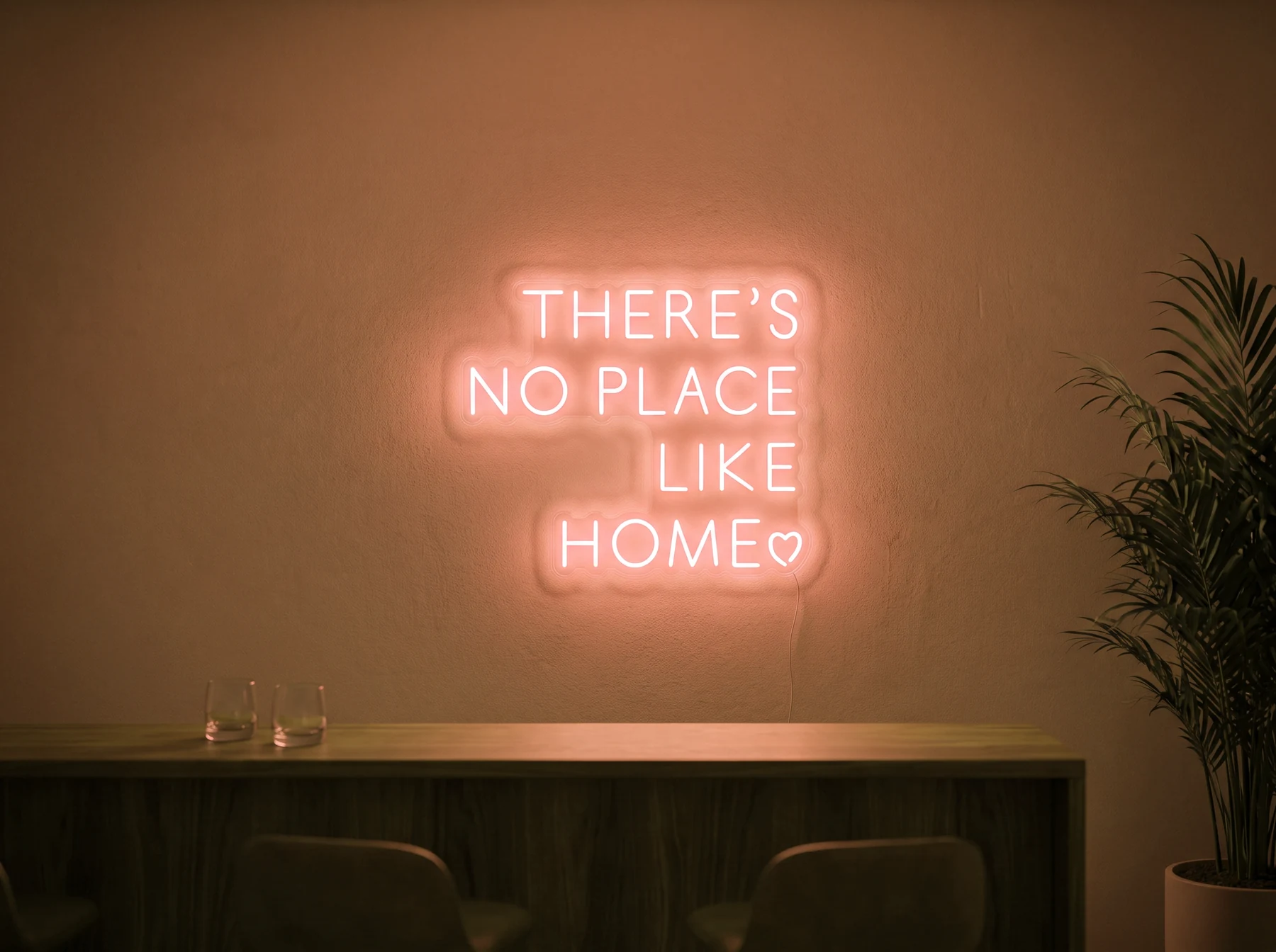 Neonskylt «There’s No Place Like Home, versaler» i orange LED-neon, monterad på vägg