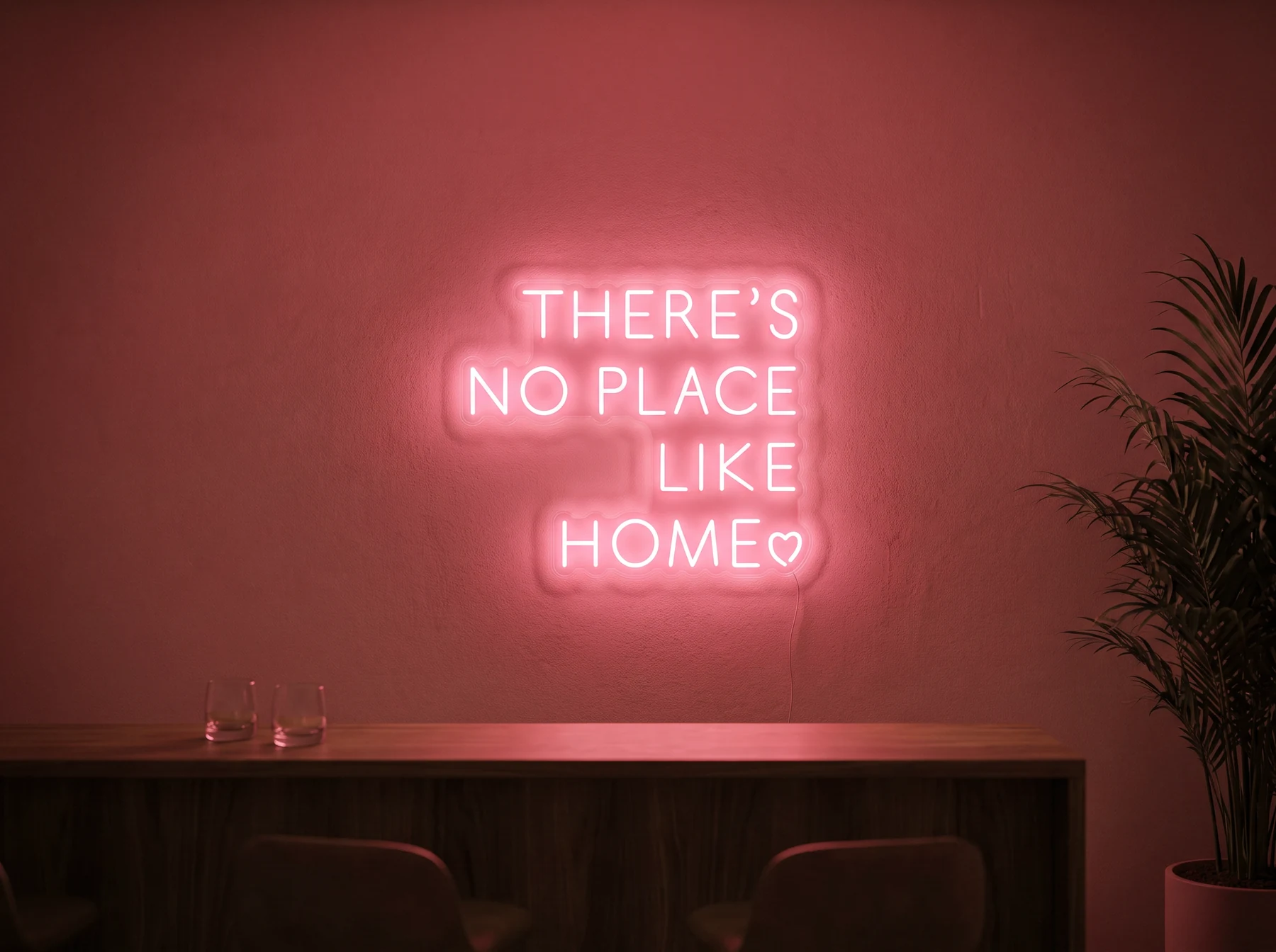 Neonskylt «There’s No Place Like Home, versaler» i röd LED-neon, monterad på vägg