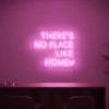 Neonskylt «There’s No Place Like Home, versaler» i rosa LED-neon, monterad på vägg