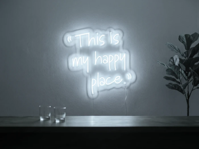 Neonskylt «This Is My Happy Place» i iskall vit LED-neon, monterad på vägg