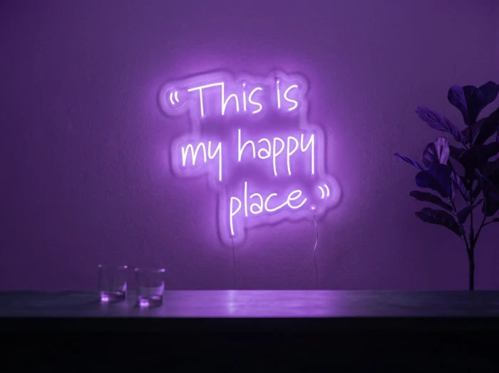 Neonskylt «This Is My Happy Place» i lila LED-neon, monterad på vägg