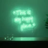 Neonskylt «This Is My Happy Place» i mintgrön LED-neon, monterad på vägg