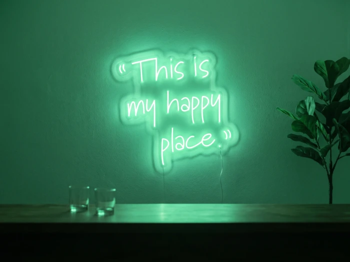 Neonskylt «This Is My Happy Place» i mintgrön LED-neon, monterad på vägg