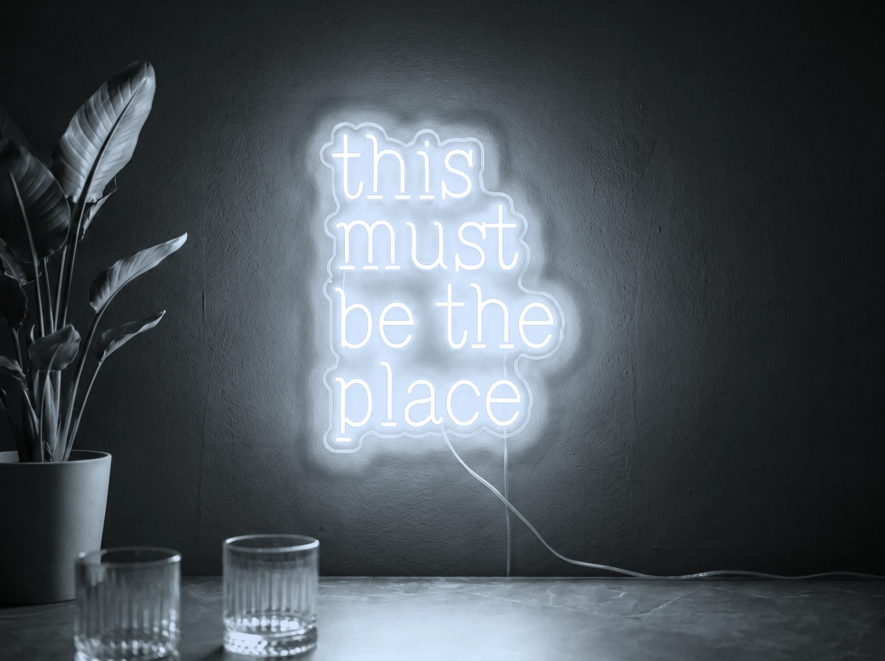 Neonskylt «This Must Be The Place» i iskall vit LED-neon, monterad på vägg