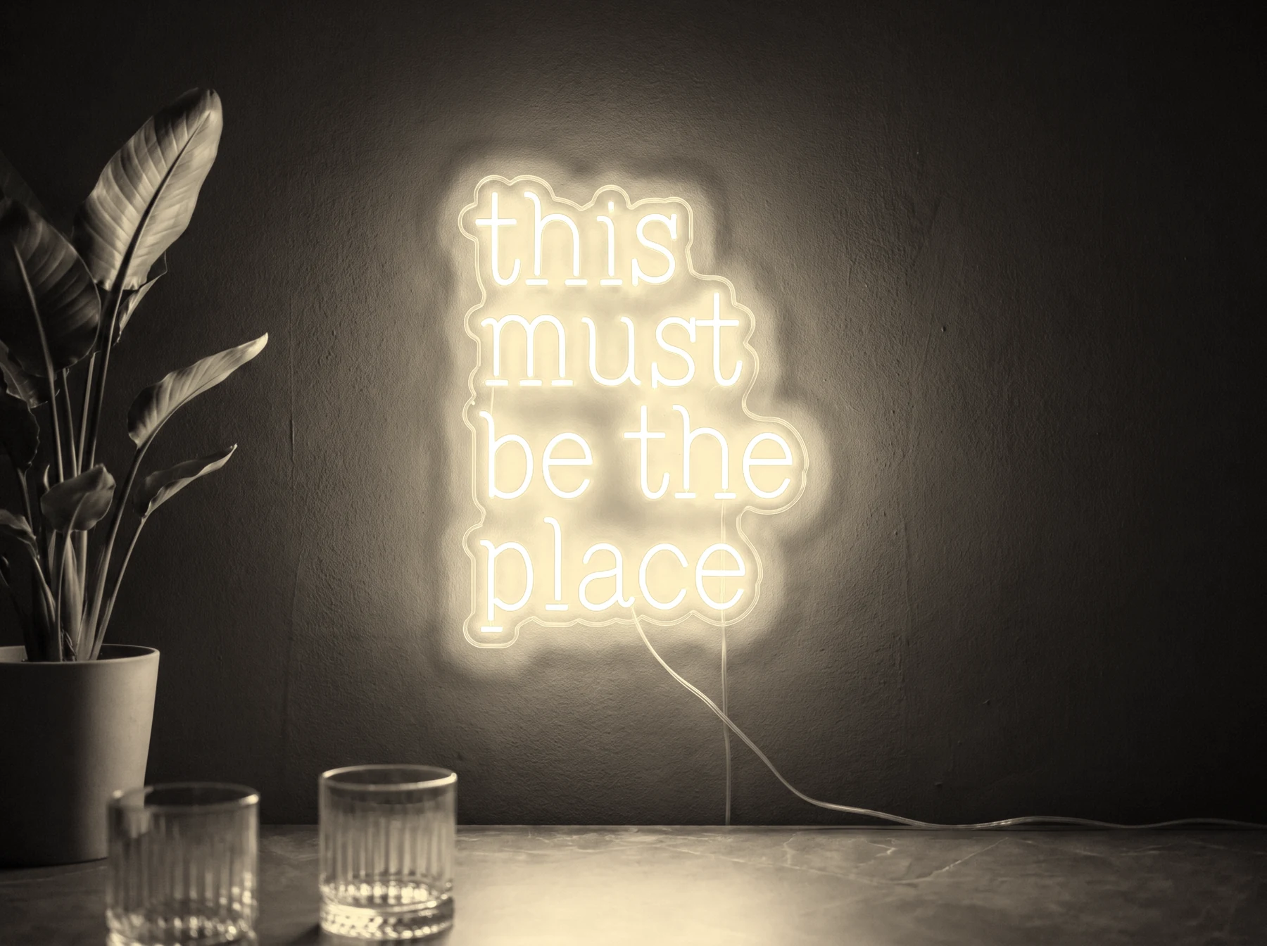 Neonskylt «This Must Be The Place» i varmvit LED-neon, monterad på vägg