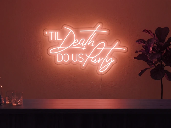 Neonskylt «Til Death Do Us Party» i röd LED-neon, monterad på vägg